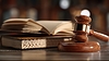 Wooden gavel and open law book on courtroom desk | Stock Foto