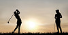 Women playing golf at sunset
