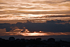 Himmel bei Sonnenuntergang, der über silhouettierter Stadt im Krieg leuchtet | Stock Foto