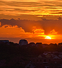 Siluetas urbanas bajo una puesta de sol resplandeciente, en capas | Foto de stock